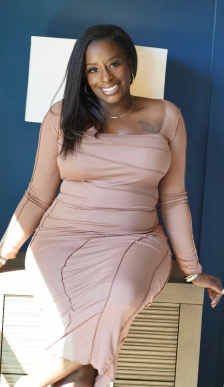 Shana Pratt smiling, seated in a blush dress